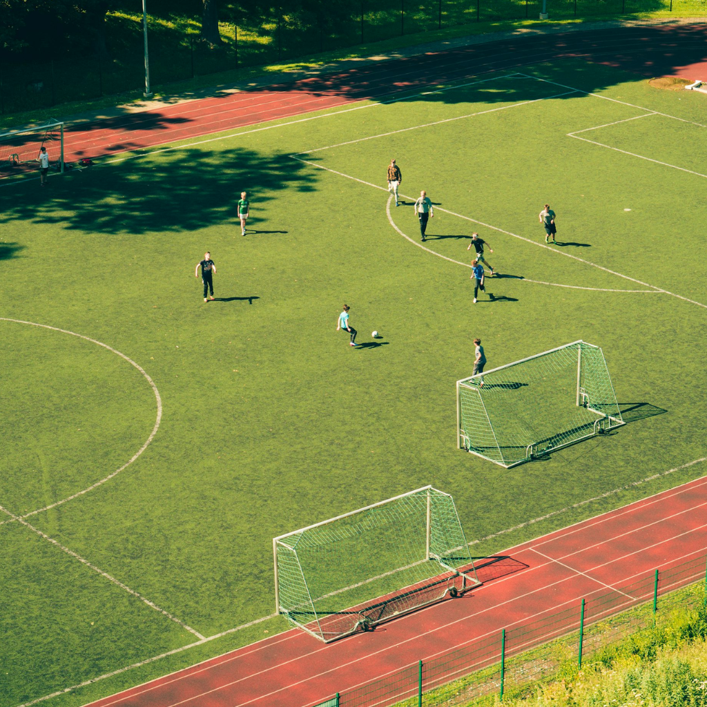 garotos jogando futebol em campo